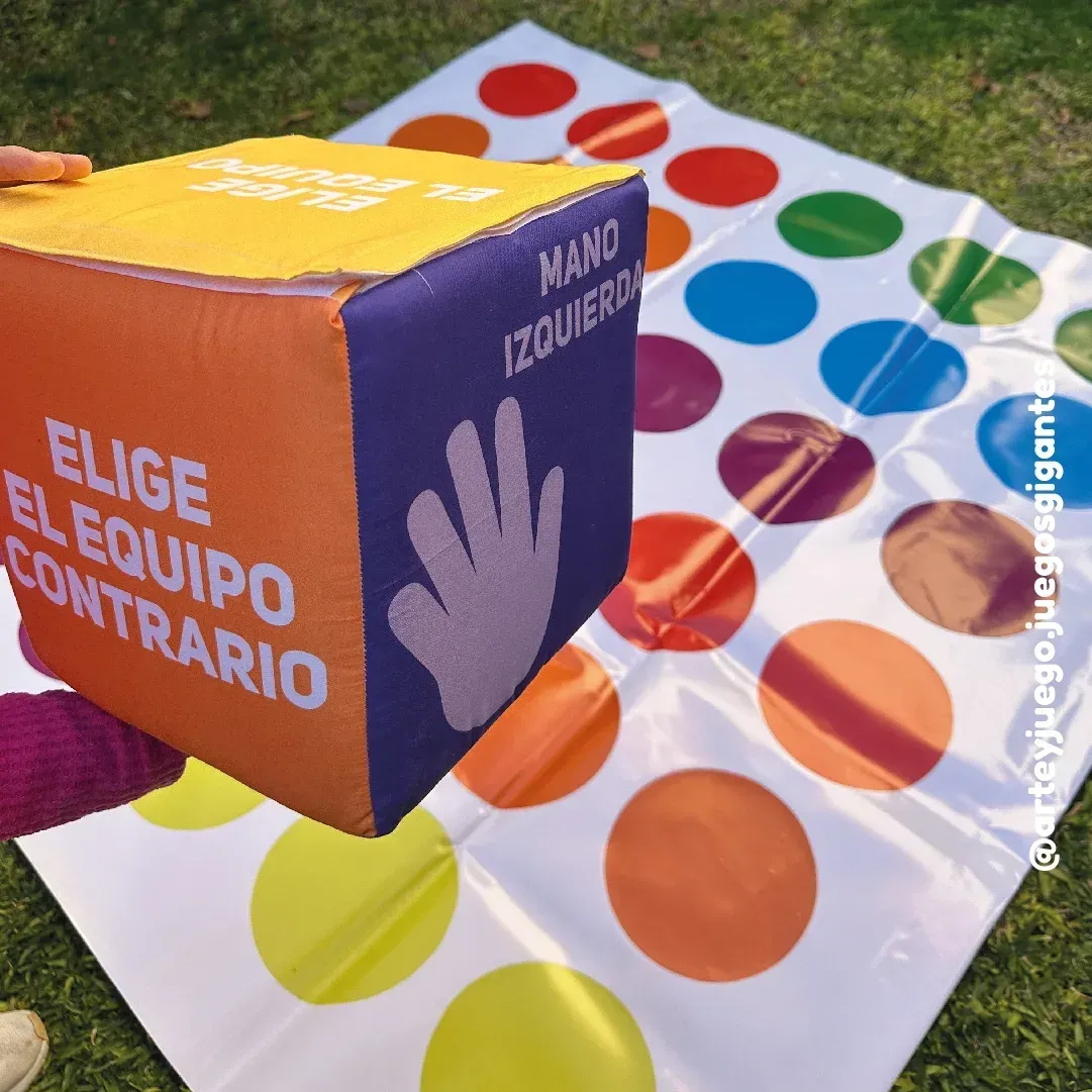 Twister Gigante 150x150: dado de tela en primer plano y lona con círculos de colores